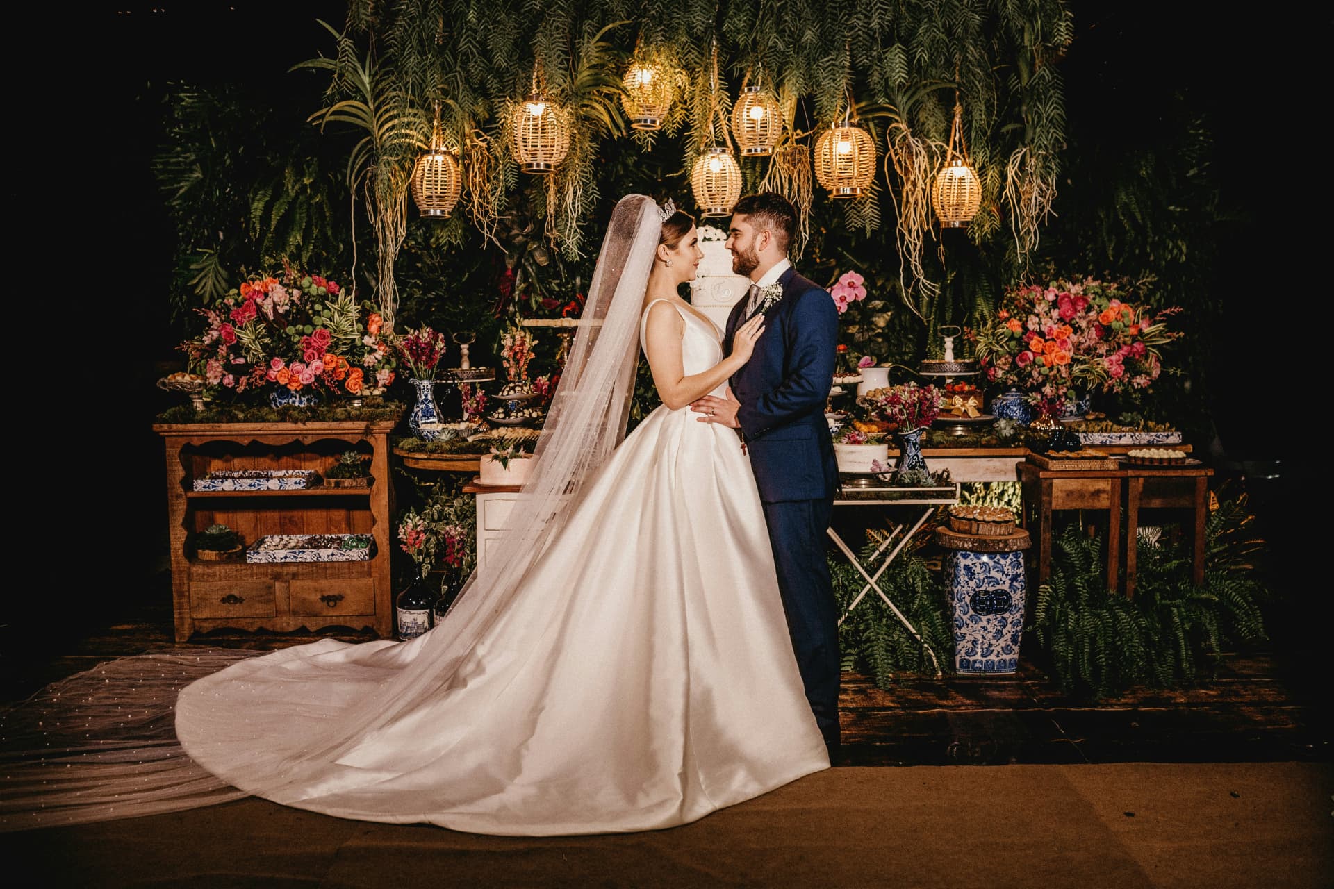 Novios frente a una decoración floral iluminada de noche