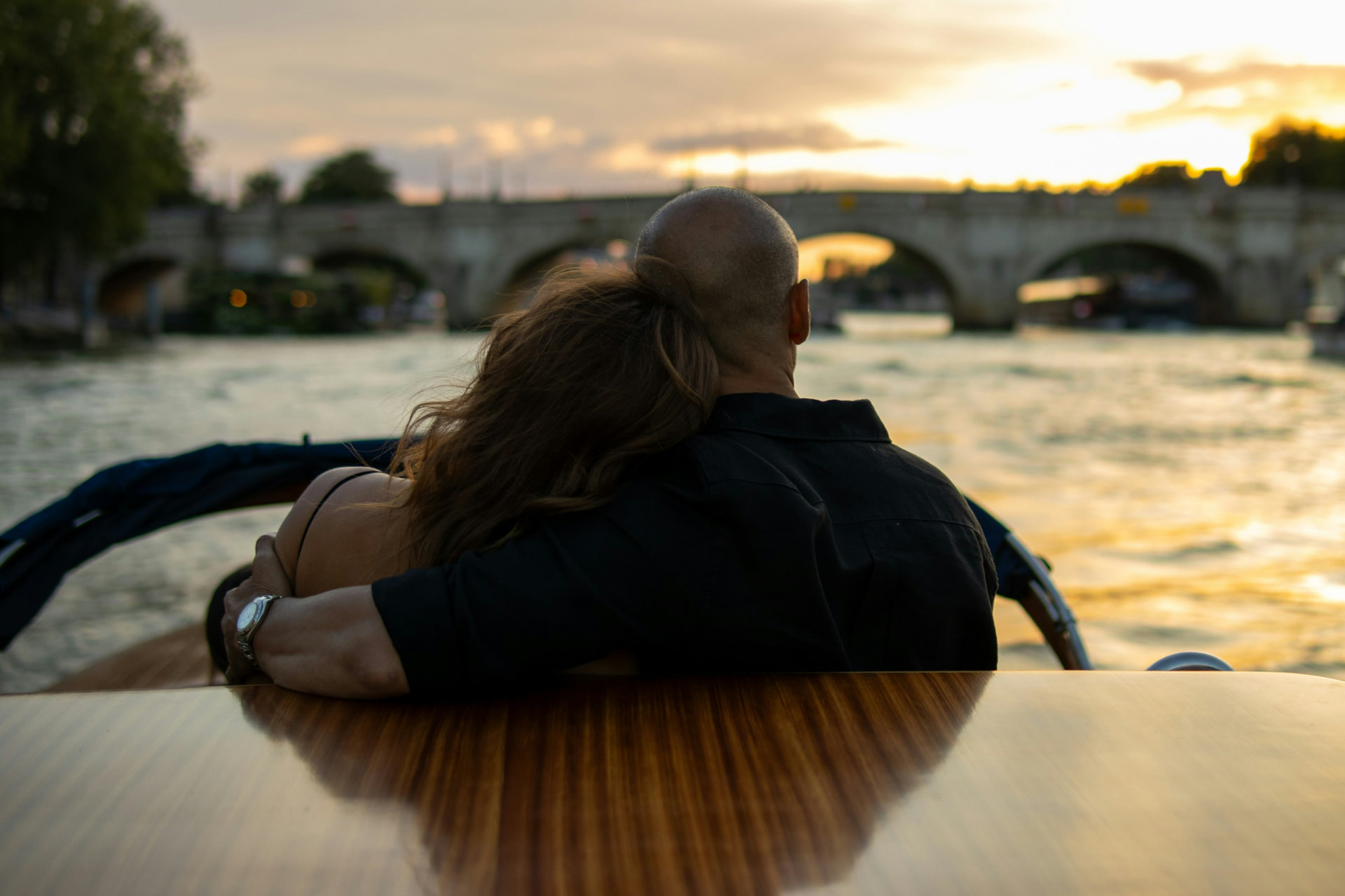 Pareja abrazada en un barco sobre el Sena al atardecer