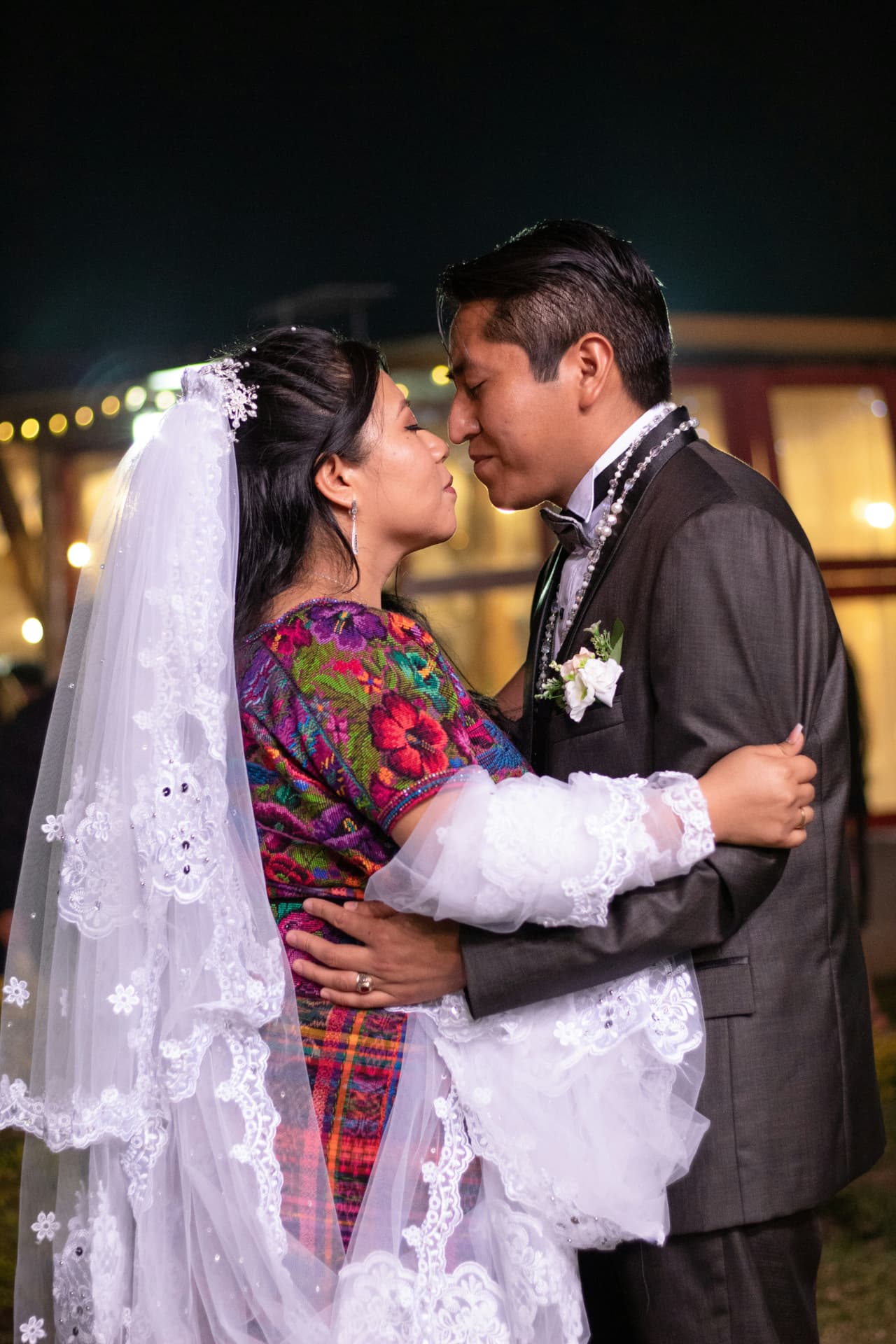 Novios con traje tradicional durante la noche