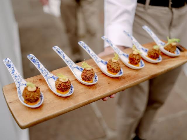 Amuse-bouches servidos en cucharas de porcelana azul