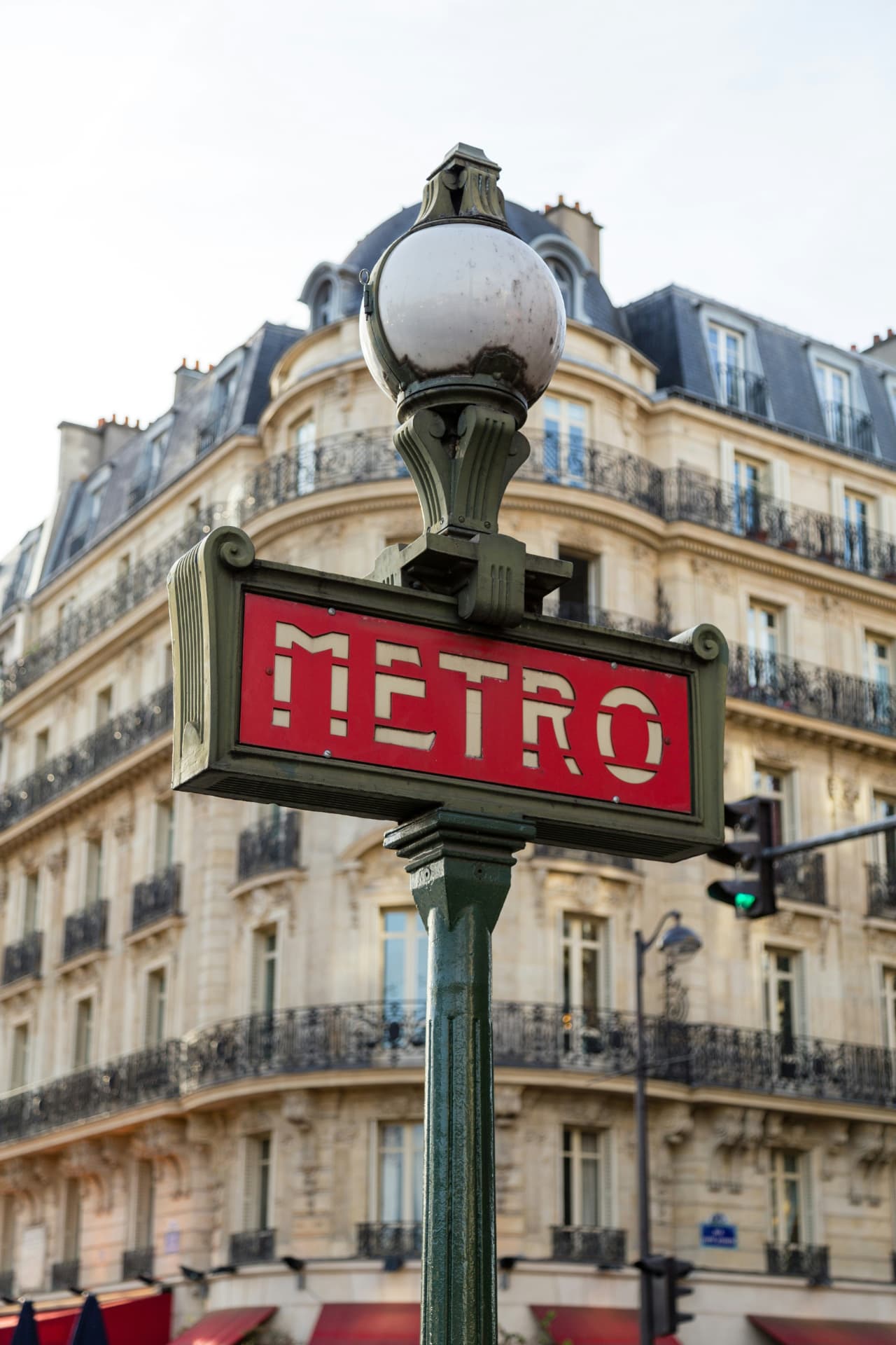 Cartel de metro parisino frente a un edificio haussmanniano