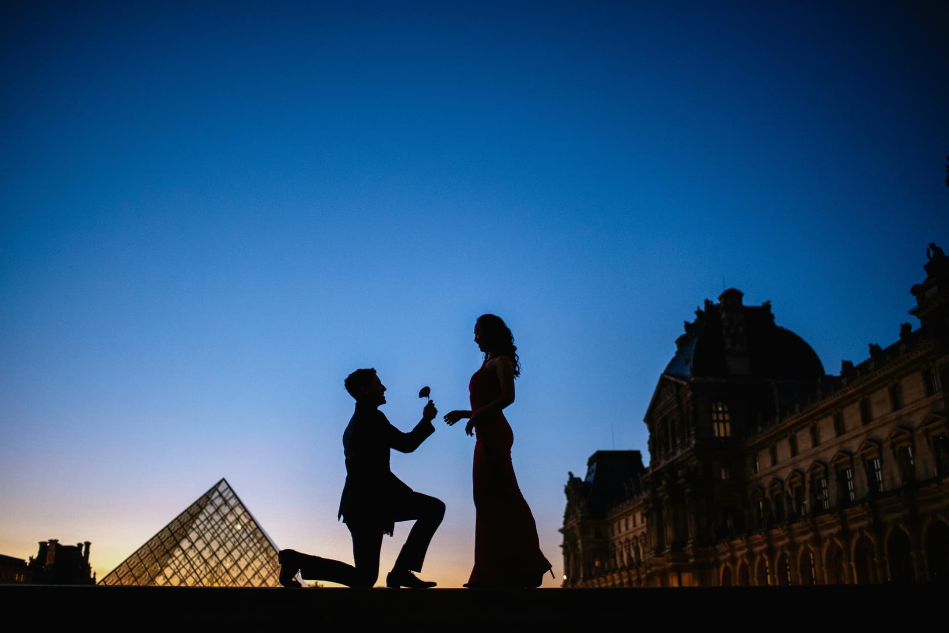 Propuesta de matrimonio ante la pirámide del Louvre al atardecer