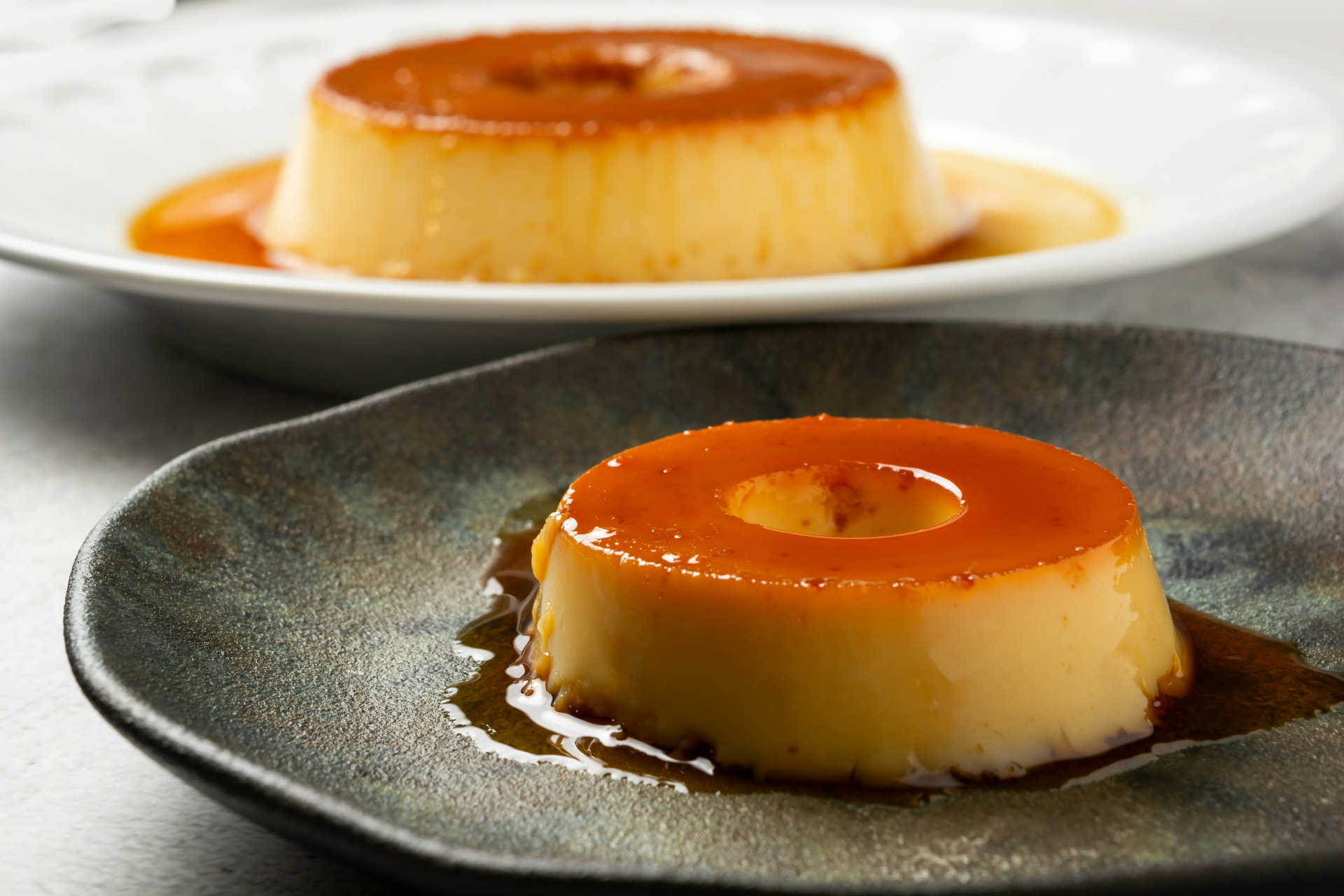 Dos cremas caramelizadas servidas en platos